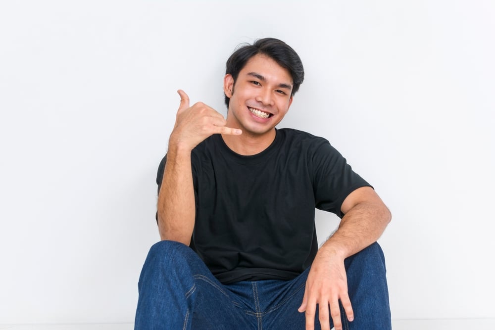 Man making the "call me" hand gesture.