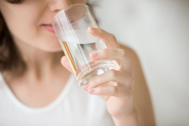 Woman drinking water from a glass.