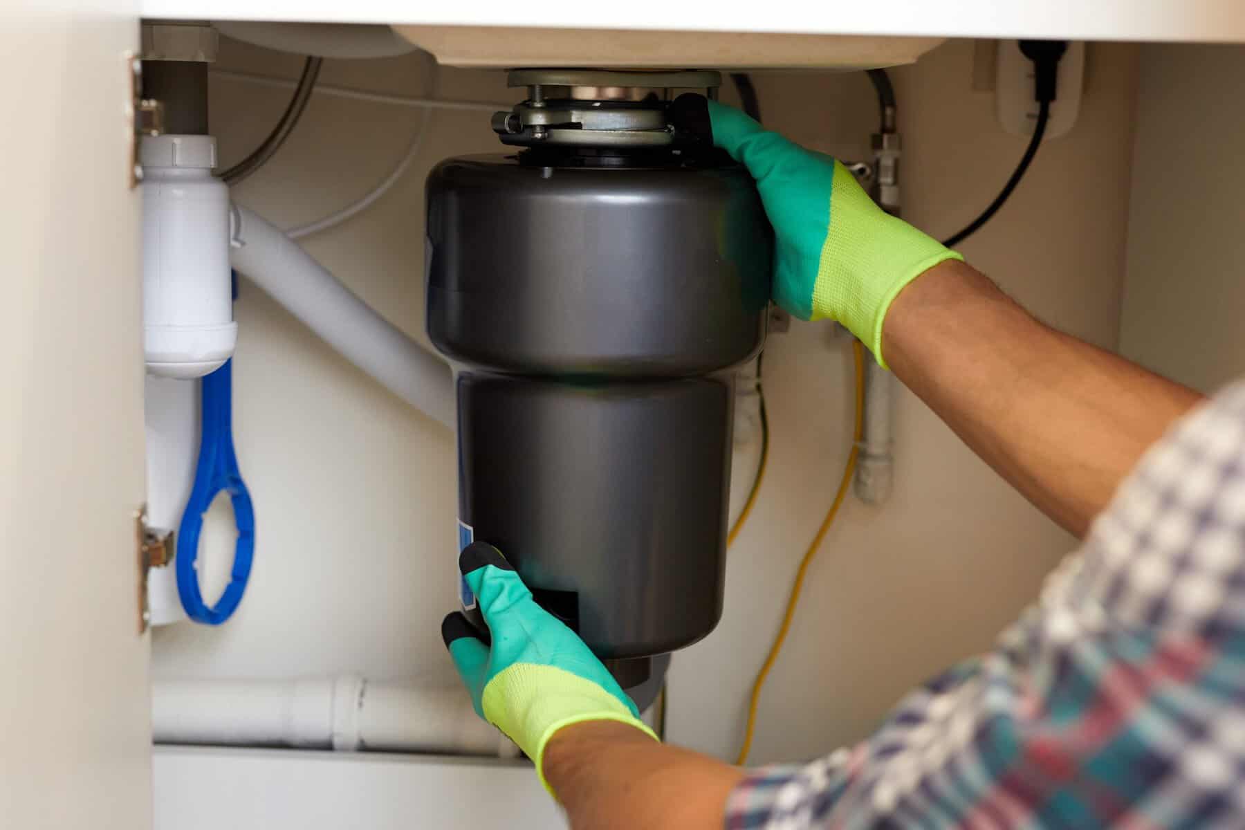 Man fixing a garbage disposal.