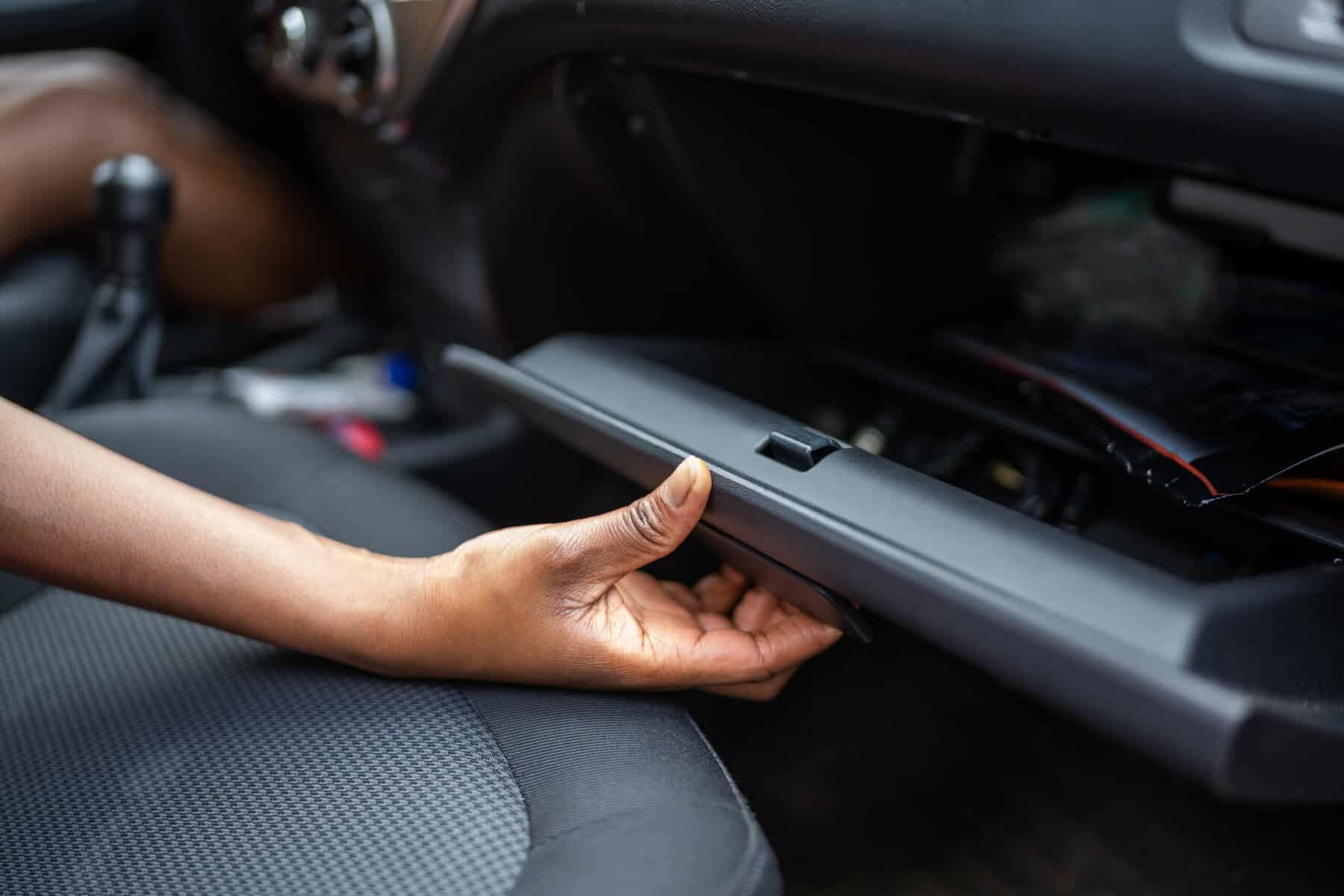 Woman reaching into her glove box.