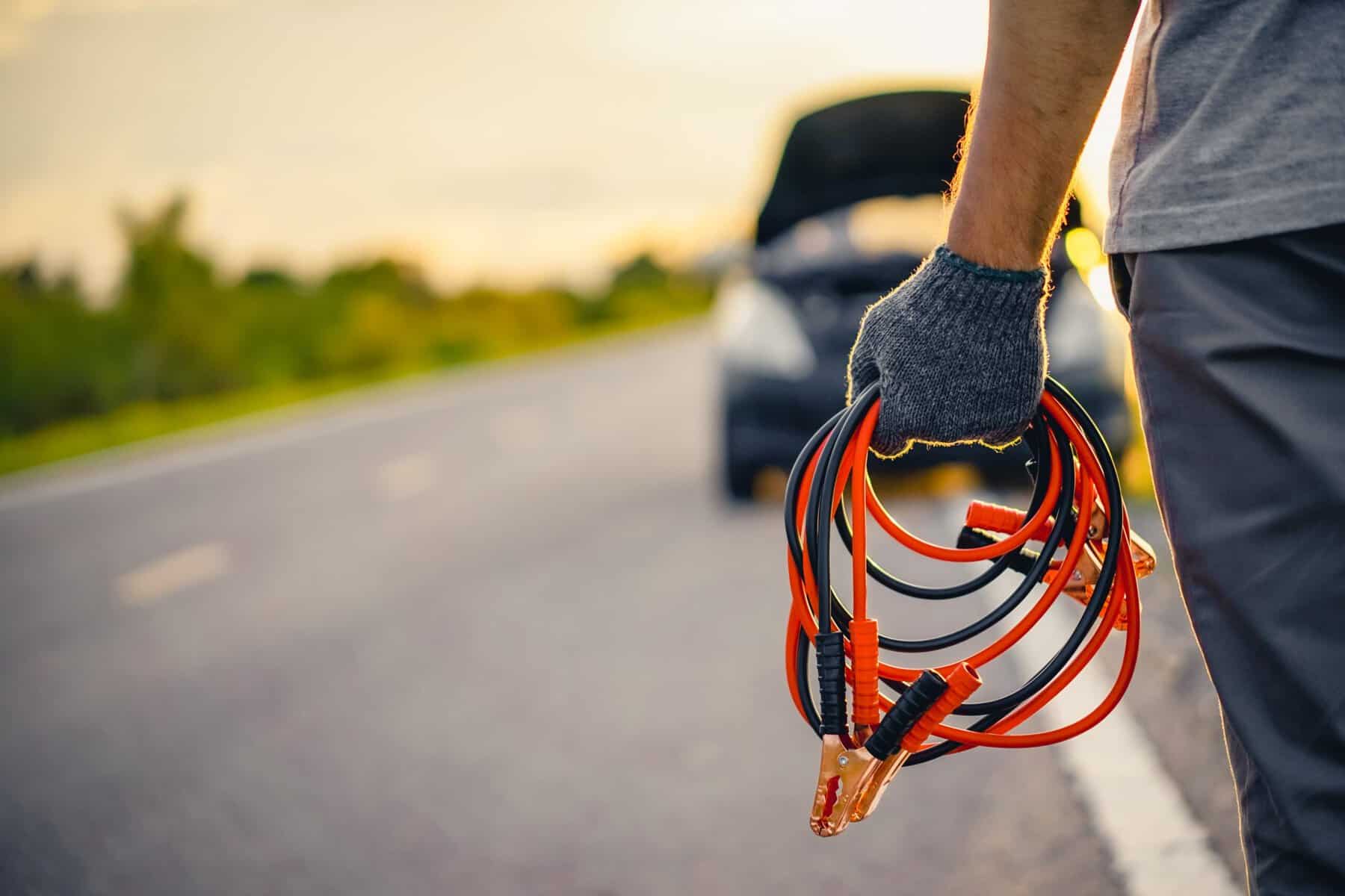 Man holding jumper cables. 