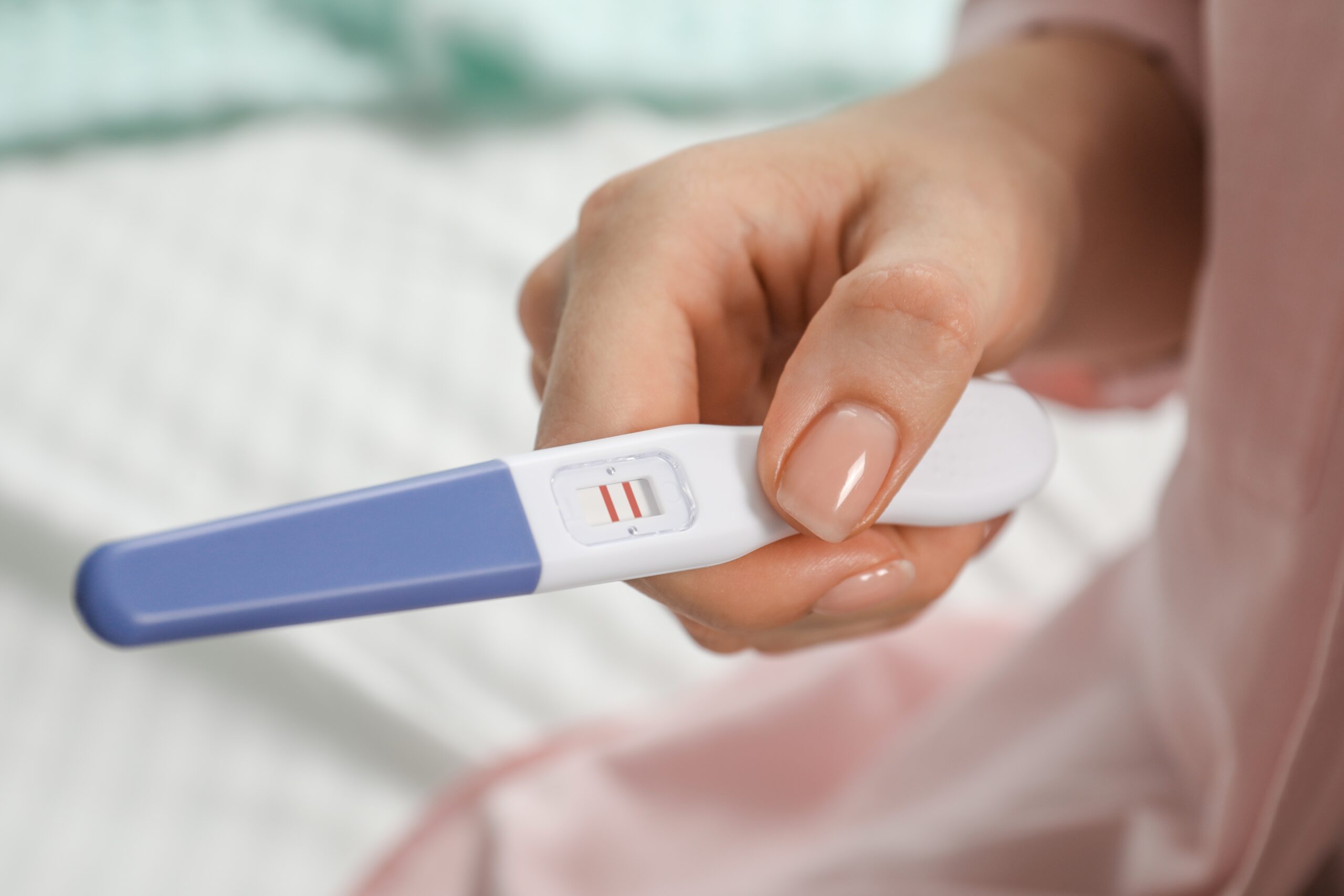 Woman holding a pregnancy test.