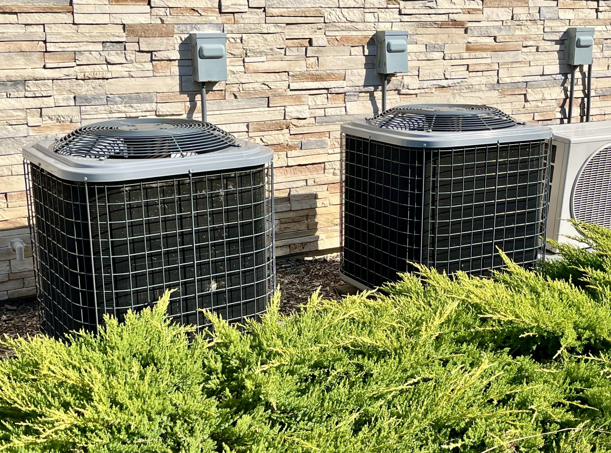 Two HVACs outside a home.
