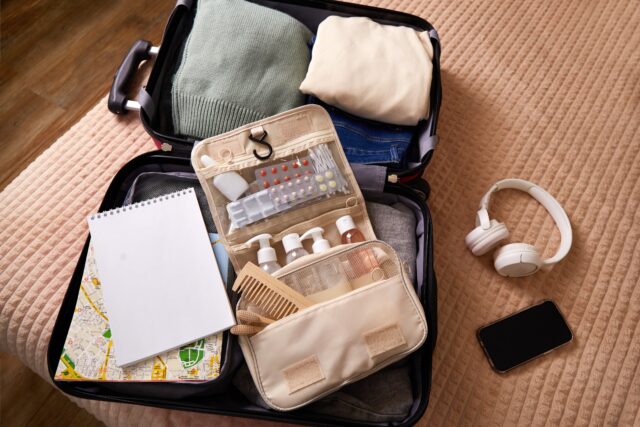 Packing suitcase with travel toiletries.
