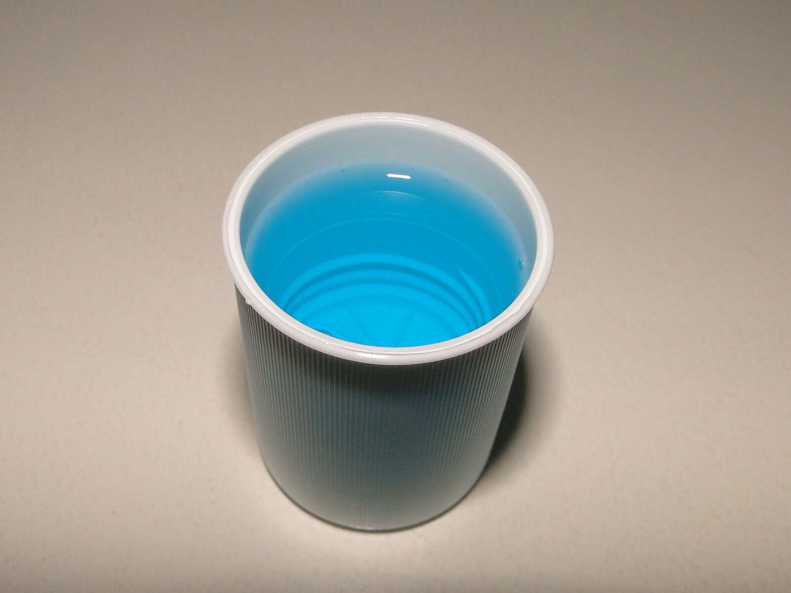 A small cup of mouthwash.
