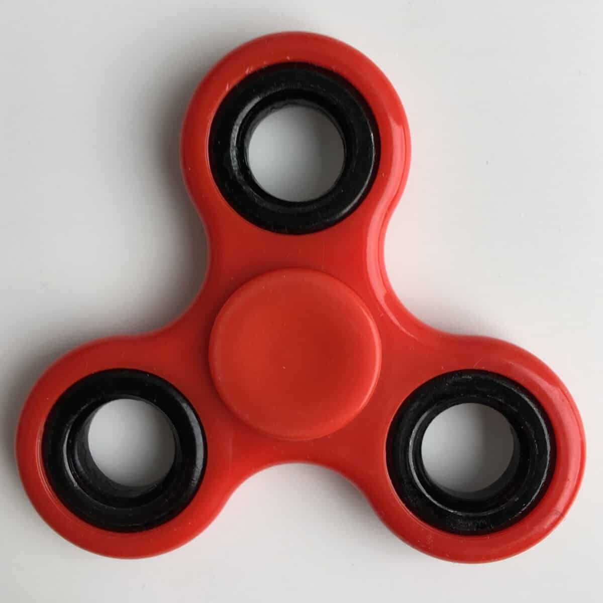 A red fidget spinner toy.
