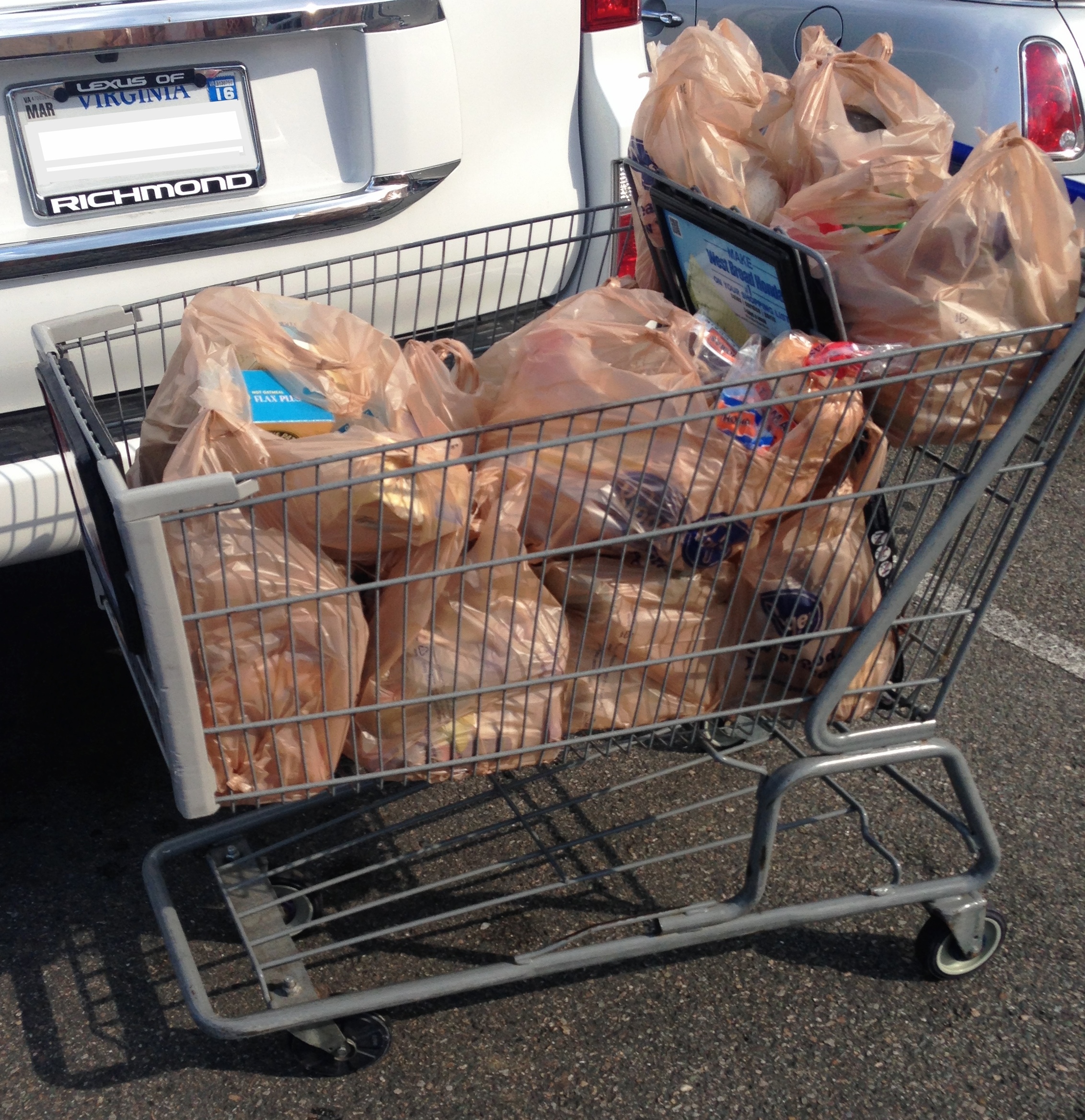 A shopping cart full of bagged groceries.
