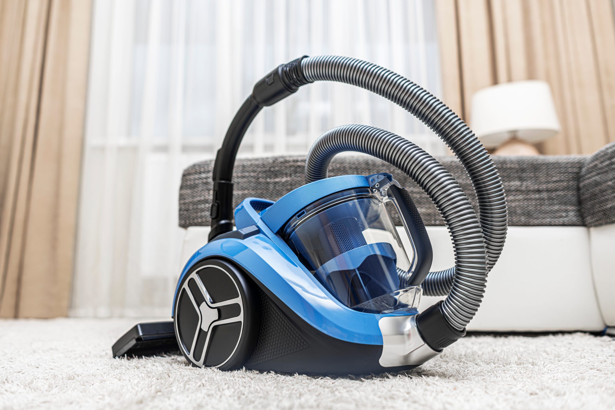 A vacuum cleaner on the living room carpet.