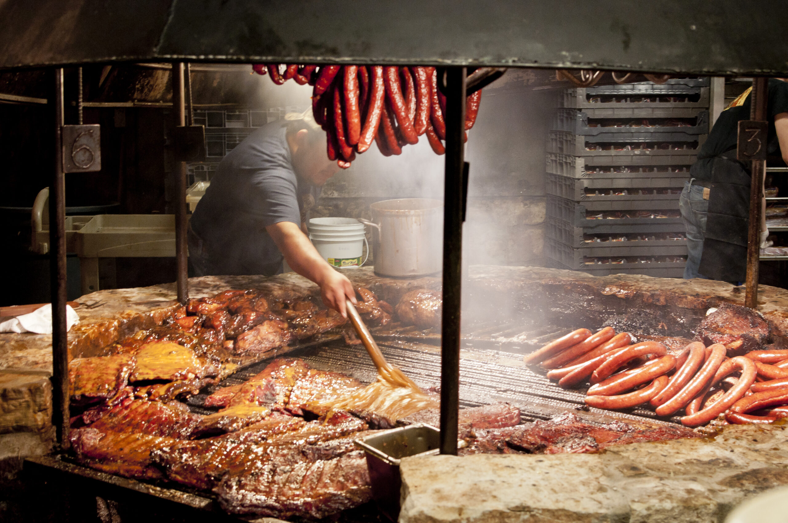 A man at the BBQ grilling meat.