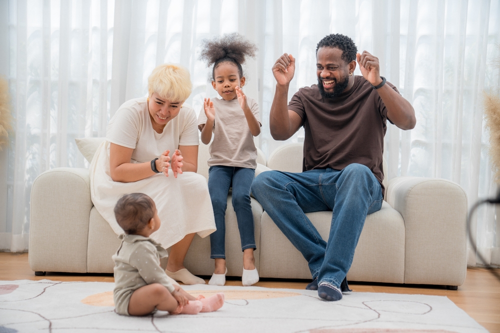 A young couple spend quality time with their two children, and applauding the younger child