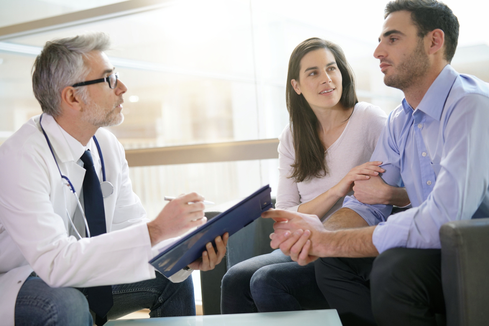 Couple meeting medical specialist together at hospital