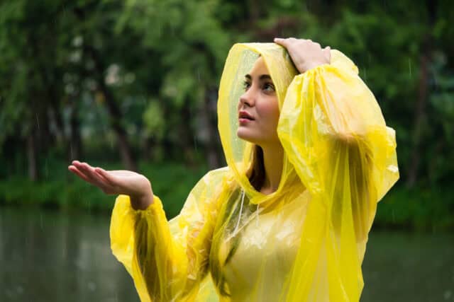 Happy Woman, in yellow Poncho enjoying the rain.