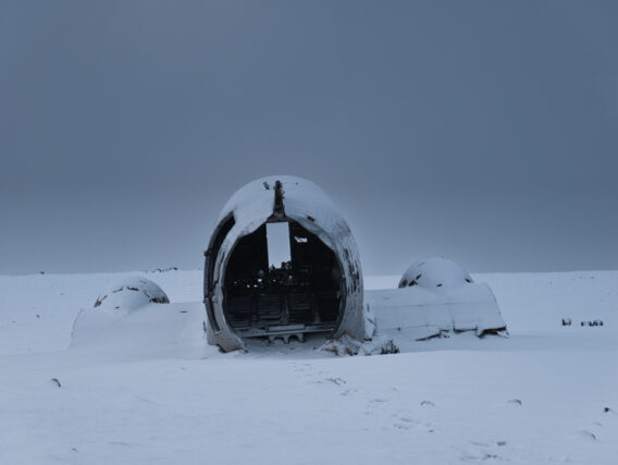 Tail end of an old plane wreck in the snow.
