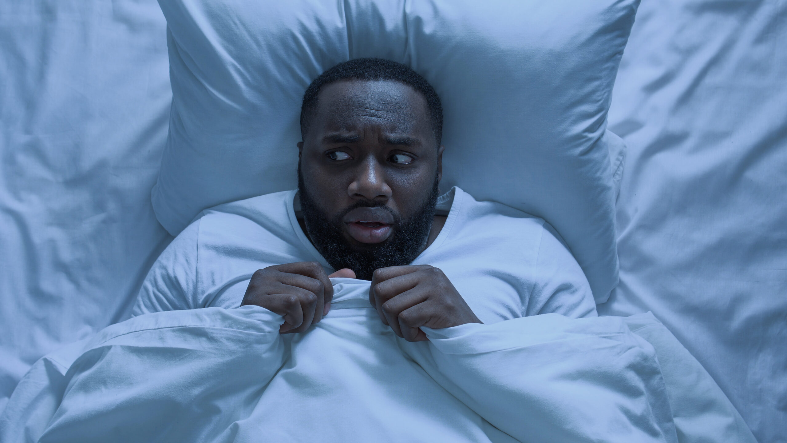 adult male in bed scared