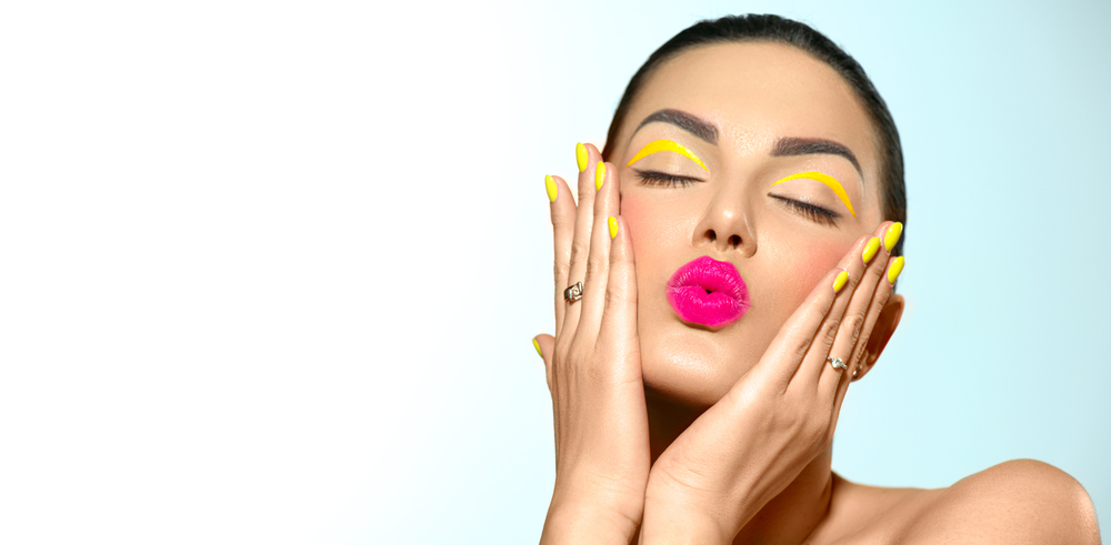 Beauty image of gorgeous woman with pink lipstick and yellow nails and eye shadow