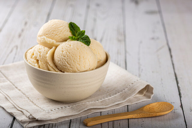 bowl of vanilla ice cream with wooden spoon