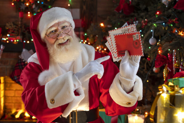 Santa Claus reading letters sent to him from Children