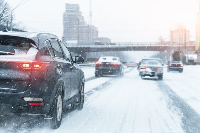 Traffic driving on snow covered road.