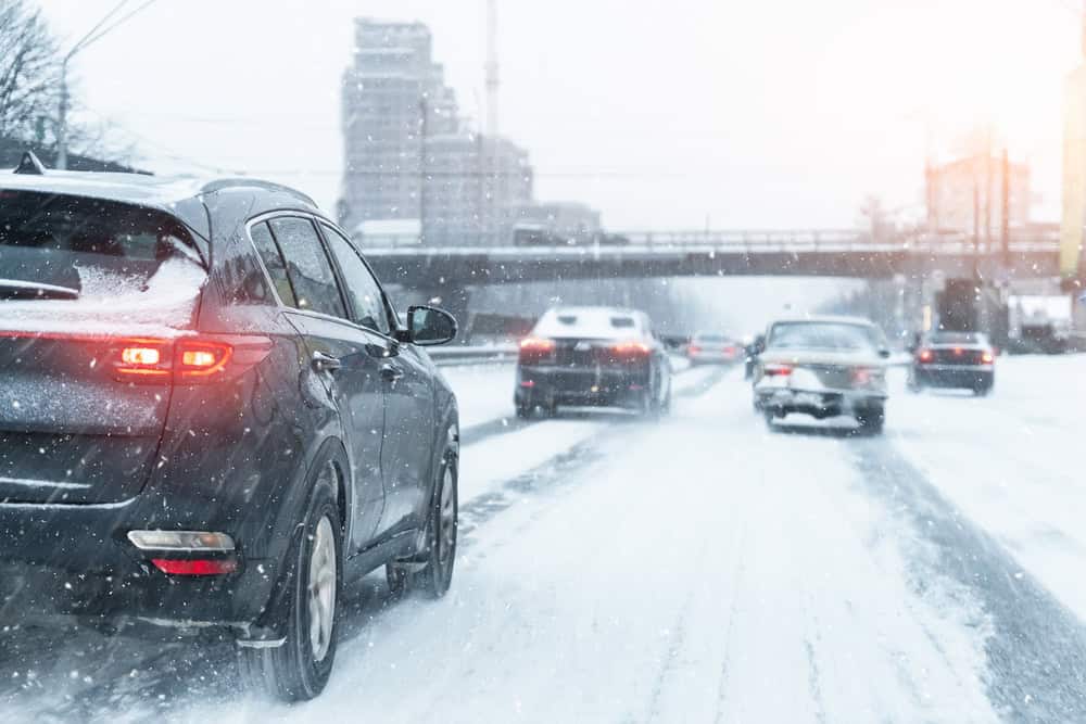 Traffic driving on snow covered road.
