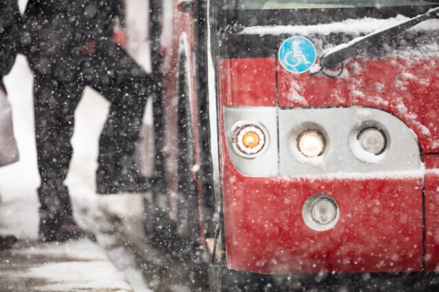 Bus stop, passenger getting on bus in snow
