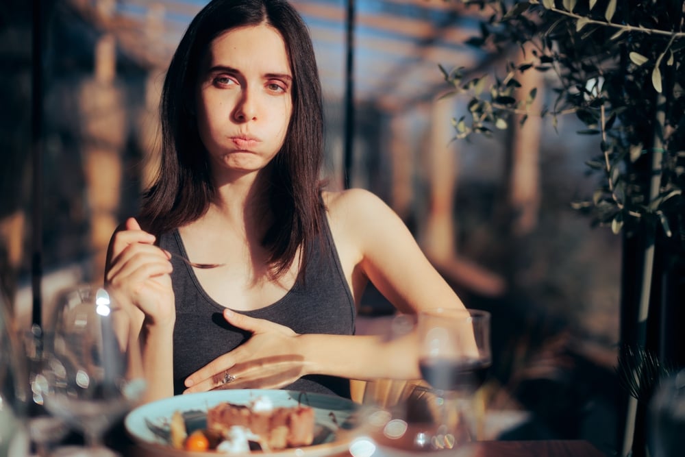 Women eating with an upset tummy or digestive issues.