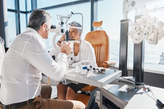 Eye doctor performing eye exam on patient