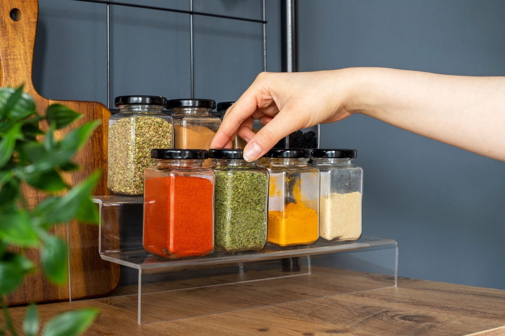 hand reaching for a jar of spices.
