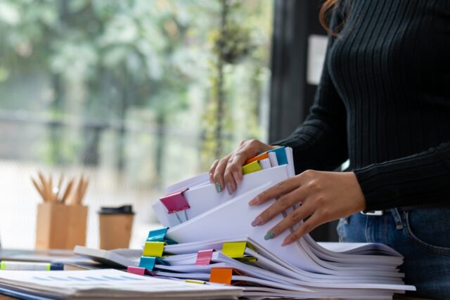 Office worker Searching through piles of documents.