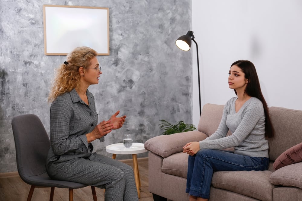 Therapy session, Young woman getting a professional help from an adult female counselor in her office