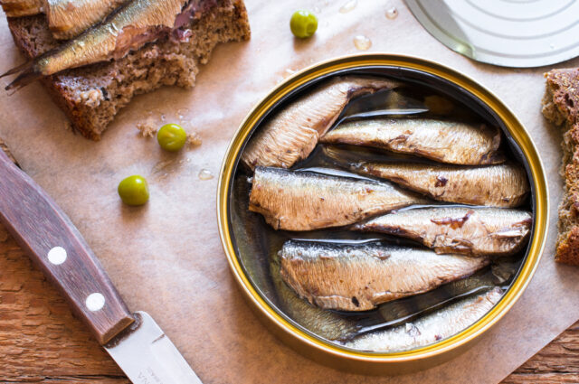 Open tin of sardines, sardines on bread.