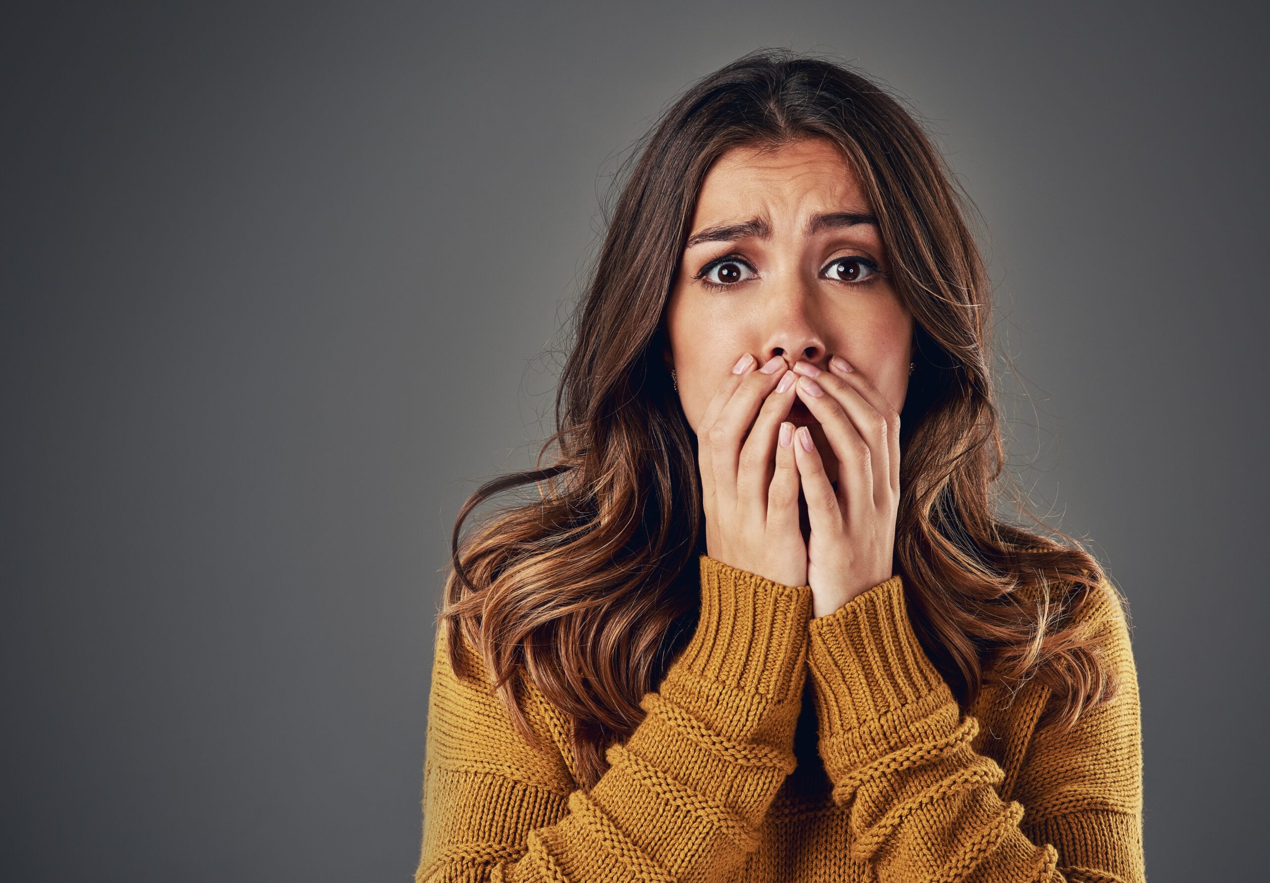 scared woman covering mouth
