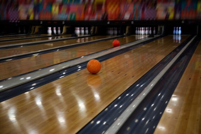 Bowling ball rolling down bowling alley.