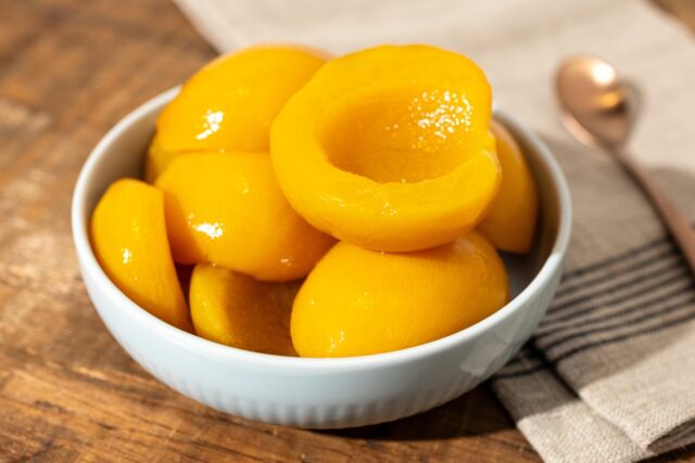 Close up bowl of tinned peaches.
