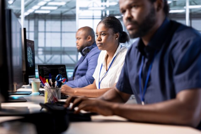 Team of Data engineers working on computers.