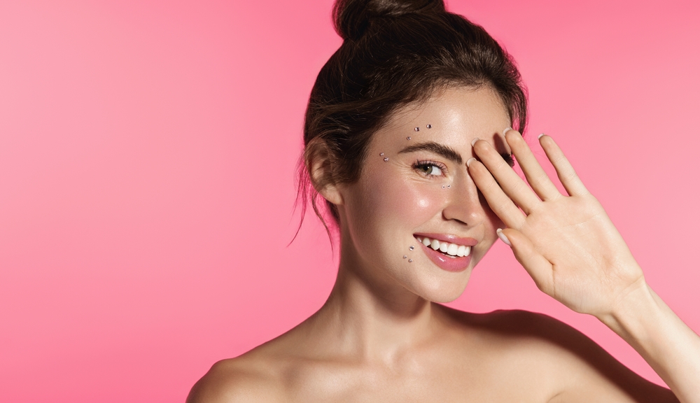 Beauty shot of a woman with glowing skin, blush and a hint of lipstick.