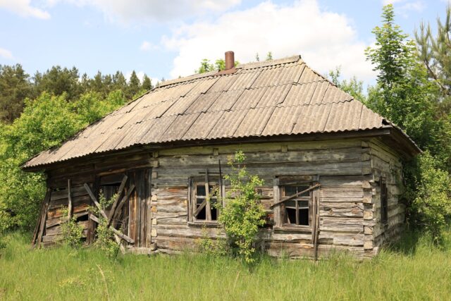 Old wooden abandoned cabin in the woods.