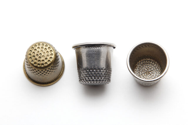 Metal thimbles on white background.