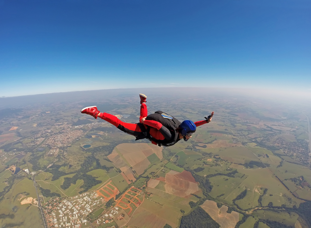 A smiling black young woman sky diving