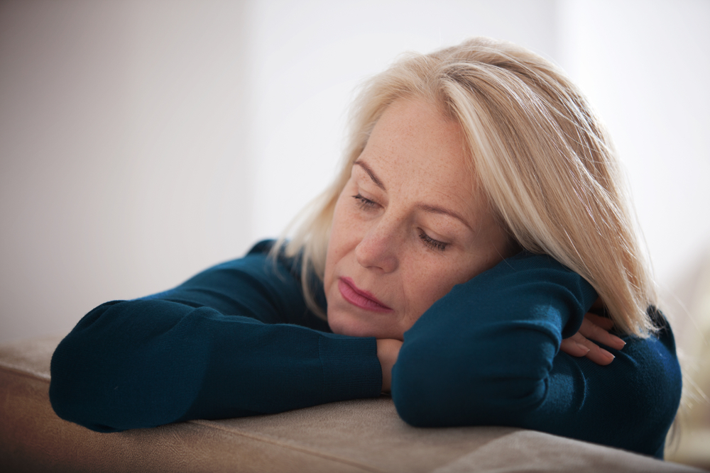 A woman sitting with grief at home alone. 