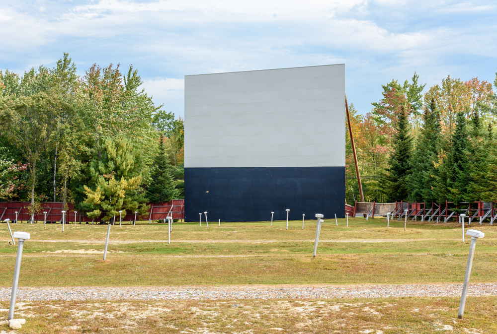 A drive-in movie theatre with projector and speakers outside