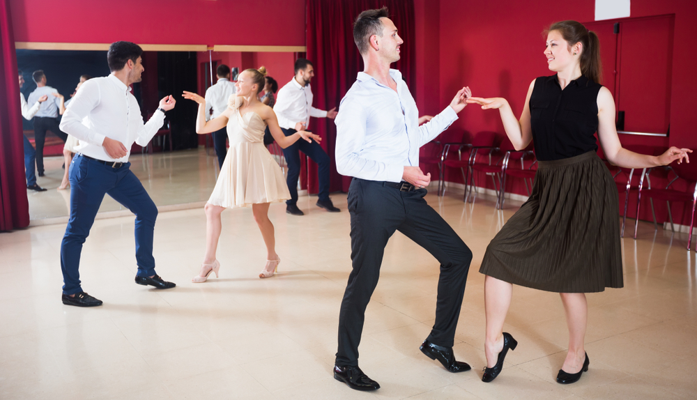 Young smiling people practicing the twist dance