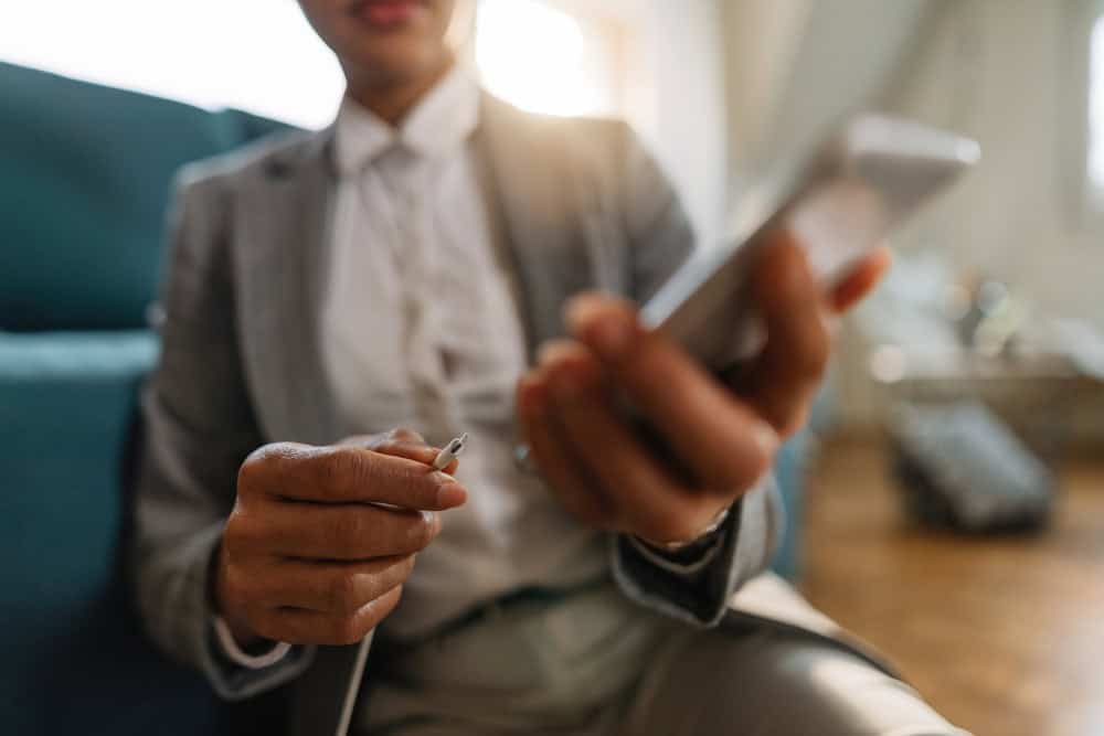 A business woman wearing suit charging her phone