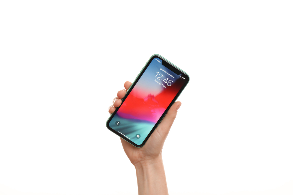 A hand holding up a locked iPhone