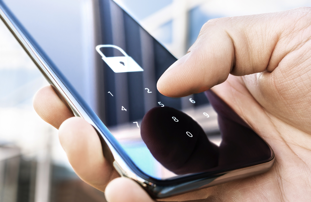 A man trying to type in his password on his locked phone