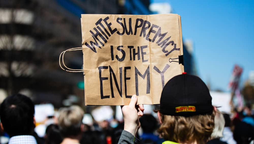 A sign reading "White supremacy is the enemy"
