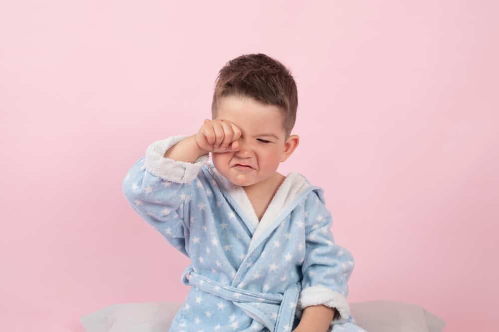 A cranky little boy refusing to go to bed