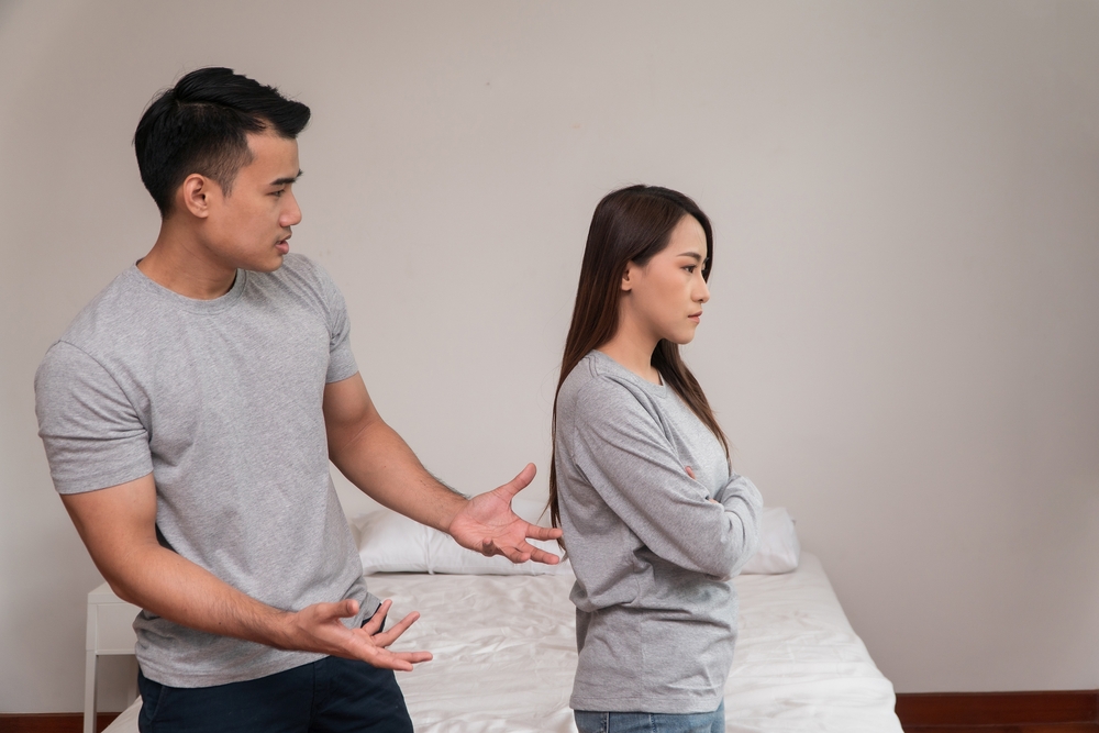A couple haveing a fight and the woman's back is turned to the man