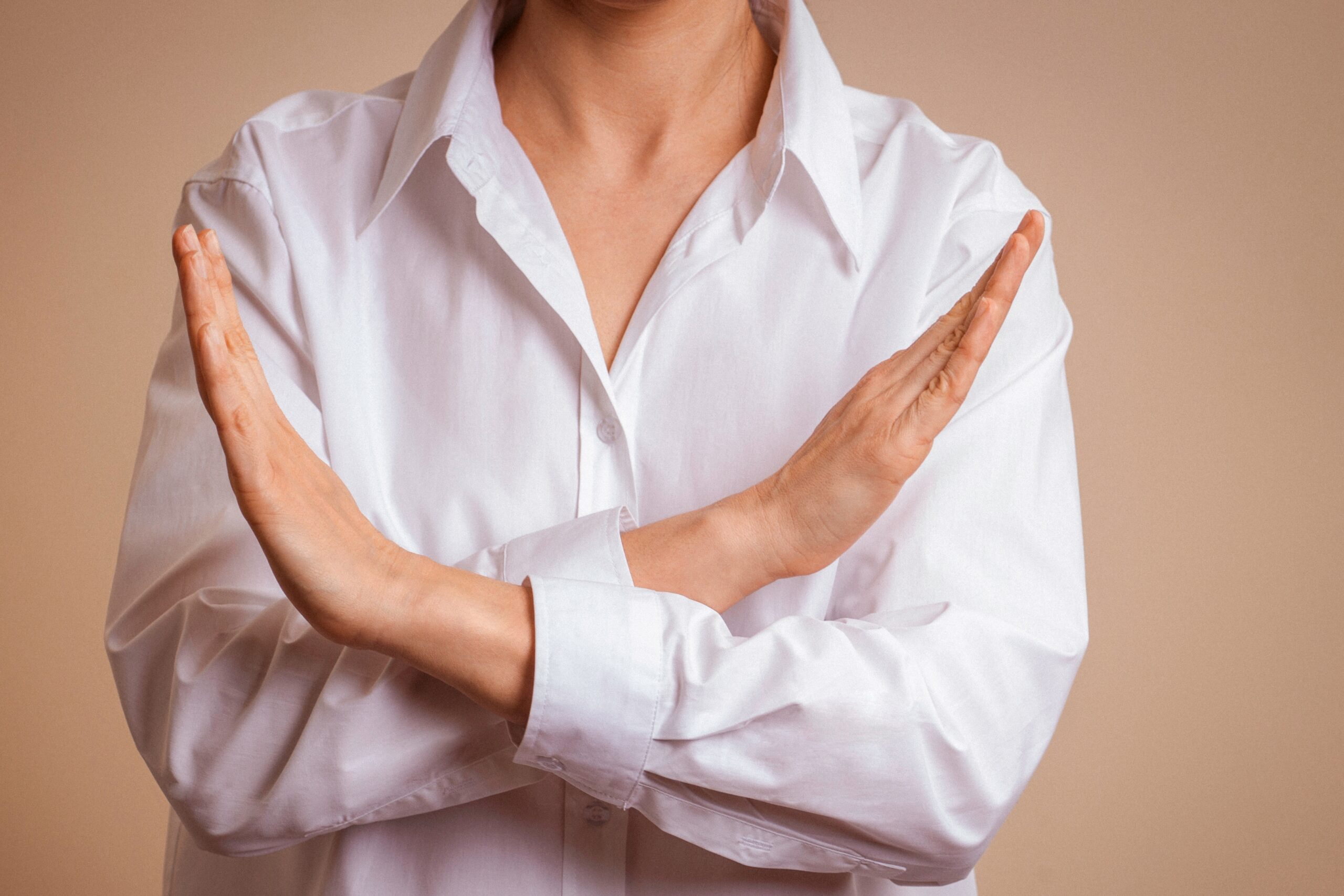 crossed hands to signal no or rejection or boundaries or conflict avoidance