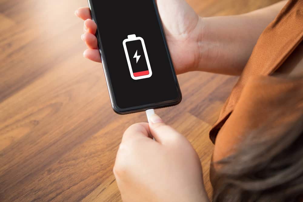 A woman plugging in her phone with her charger