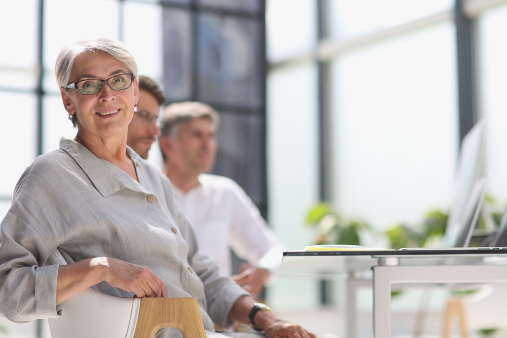 A senior woman in a business meeting with colleagues